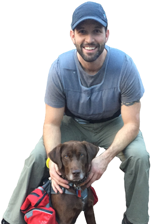 A man sitting on the ground with his dog.